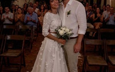 My husband’s family boycotted our wedding because he was ‘marrying down’ — two years later, my MIL came back with one unexpected request.  The day my husband and I got married, every seat reserved for his family stayed empty.  A week before the wedding, his mother had told him,  “If you marry her, don’t expect any of us to be there.”  Her reason was simple.  My mother had been a waitress for over thirty years, and my father owned a small auto repair shop.  Meanwhile, my husband’s family owned several successful businesses and had always expected him to marry someone from “their world.”  Apparently…  I wasn’t.  He married me anyway.  We had a beautiful wedding despite the empty seats, and after that, he completely cut ties with his family.  Over the next two years, we bought our first house, talked about having children, and I eventually stopped wondering whether his family would ever accept me.  Then, one rainy Saturday morning, someone knocked on our door.  When I opened it, my mother-in-law was standing there.  For several seconds, neither of us spoke.  Her eyes drifted into the house until they landed on the framed wedding photo hanging in our hallway.  She stared at it for a long moment.  “You still keep it there,” she said quietly.  I wasn’t sure how to respond.  Finally, she sighed.  “I almost turned around three times before knocking.”  For a second, I honestly thought she’d come to apologize.  I stepped aside to let her in.  “Before I show you why I came,” she said, “I need you to promise me something.”  “What?”  “Promise you won’t tell my son I came here until you’ve seen everything.”  I stared at her for a moment before finally nodding.  Only then did she pull a thick envelope from her purse and place it on the table.  “I need you to look at these.”  Inside were several photographs.  The first showed my husband sitting across from a woman at a café.  Another showed them leaving an office building together.  In a third, they were walking through a park while she appeared to be wiping tears from her face, and my husband had a hand on her shoulder.  None of the pictures proved anything.  But together…  they made my stomach twist.  I looked up at my mother-in-law.  “Who is she?”  She slowly shook her head.  “I don’t know.”  I frowned.  “Then why are you showing me this?”  She looked down at her hands.  “For two years, I kept waiting for your marriage to fall apart.”  A sad smile crossed her face.  “I was convinced my son had made the biggest mistake of his life.”  She paused before continuing.  “But it never happened.”  Another silence filled the room.  Finally, she said,  “A few weeks ago… these ended up in my hands.”  She gently pushed the envelope back toward me.  “I don’t know who that woman is.”  “I thought you needed to know the truth.”  After she left, I sat at the kitchen table for nearly an hour.  I kept trying to come up with innocent explanations.  Then I remembered a business trip he’d unexpectedly extended by a day. A few weeks later, he’d stepped outside to answer a phone call, saying he needed better reception.  Around the same time, I’d found a receipt from a restaurant he’d never mentioned. None of those moments had seemed important back then.  Looking at the photographs now…  I wasn’t so sure anymore.  When my husband came home that evening, I was still sitting at the kitchen table with the envelope in front of me.  He smiled as he walked through the door.  Then his eyes landed on the photographs.  The smile disappeared immediately.  I picked up one of them.  My hands were shaking.  “Who is she?”  He stared at the picture for several long seconds.  Then he looked at me.  “… Mom showed you these?”  “Yes.”  He didn’t answer right away.  Instead, he asked quietly,  “Did she make you promise not to tell me she’d been here?”  I felt my stomach drop.  “Yes.”  He closed his eyes.  “Then she already knows exactly what she’s done.” Read the REST of this story in 1st comment⬇️