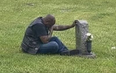 A BIKER CAME TO MY WIFE’S GRAVE EVERY SINGLE WEEK, AND FOR MONTHS, I HAD NO IDEA WHO HE WAS. _____ For six months, I watched him from inside my car. Same day. Same time. Every Saturday at exactly 2 PM, he would ride into the cemetery on his Harley, park near the old oak tree, and walk straight to Emily’s headstone. Then he would sit beside her grave for one full hour. He never brought flowers. Never left a note. Never spoke loud enough for me to hear. He just sat cross-legged in the grass, head lowered, like he was carrying a pain too heavy to stand with. The first time I saw him, I thought he had made a mistake. It was a large cemetery. Graves could be easy to confuse. But then he came back the next Saturday. And the Saturday after that. And again after that. Week after week, this stranger mourned my wife like she had belonged to him too. At first, I was confused. Then I became angry. Who was he? How did he know Emily? Why was this man showing up for her every week when some people in her own family barely came at all? Emily had died fourteen months earlier from breast cancer. She was only forty-three. We had been married for twenty years. Two children. A quiet home. A normal life. At least, that was what I thought. Nothing about my wife’s life made sense with this man. Emily had been a pediatric nurse. She volunteered at church. She drove a silver minivan and packed snacks for every school event. Her idea of breaking the rules was ordering dessert before dinner. But this biker grieved her like he had lost someone irreplaceable. Sometimes, from my car, I saw his shoulders shake. Sometimes, before he left, he placed one rough hand against her headstone and kept it there for several seconds. Like he was saying goodbye all over again. By the third month, I could not take it anymore. That Saturday, I stepped out of my car and walked toward him. He heard my footsteps but did not turn around. His hand stayed pressed against Emily’s name. “Excuse me,” I said, my voice sharper than I intended. “I’m Emily’s husband. I think it’s time you told me who you are.” For a long moment, he said nothing. Then he slowly stood, turned toward me, and looked like a man who had been waiting six months for this question. Finally, he said: “Your wife was my…” Type “0503” and hit “Like” to see the full story.